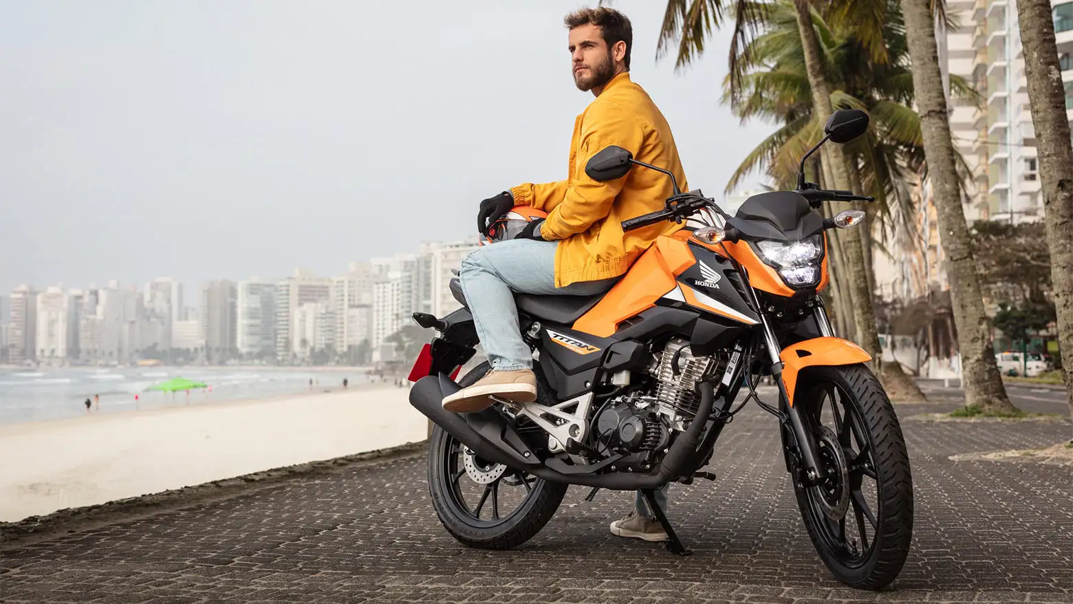 homem-observando-a-paisagem-sentado-na-honda-cg-160-titan-laranja.webp